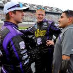 members of the infinite hero race crew chat at the Daytona Speedway