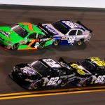 four cars drive around the speedway at daytona